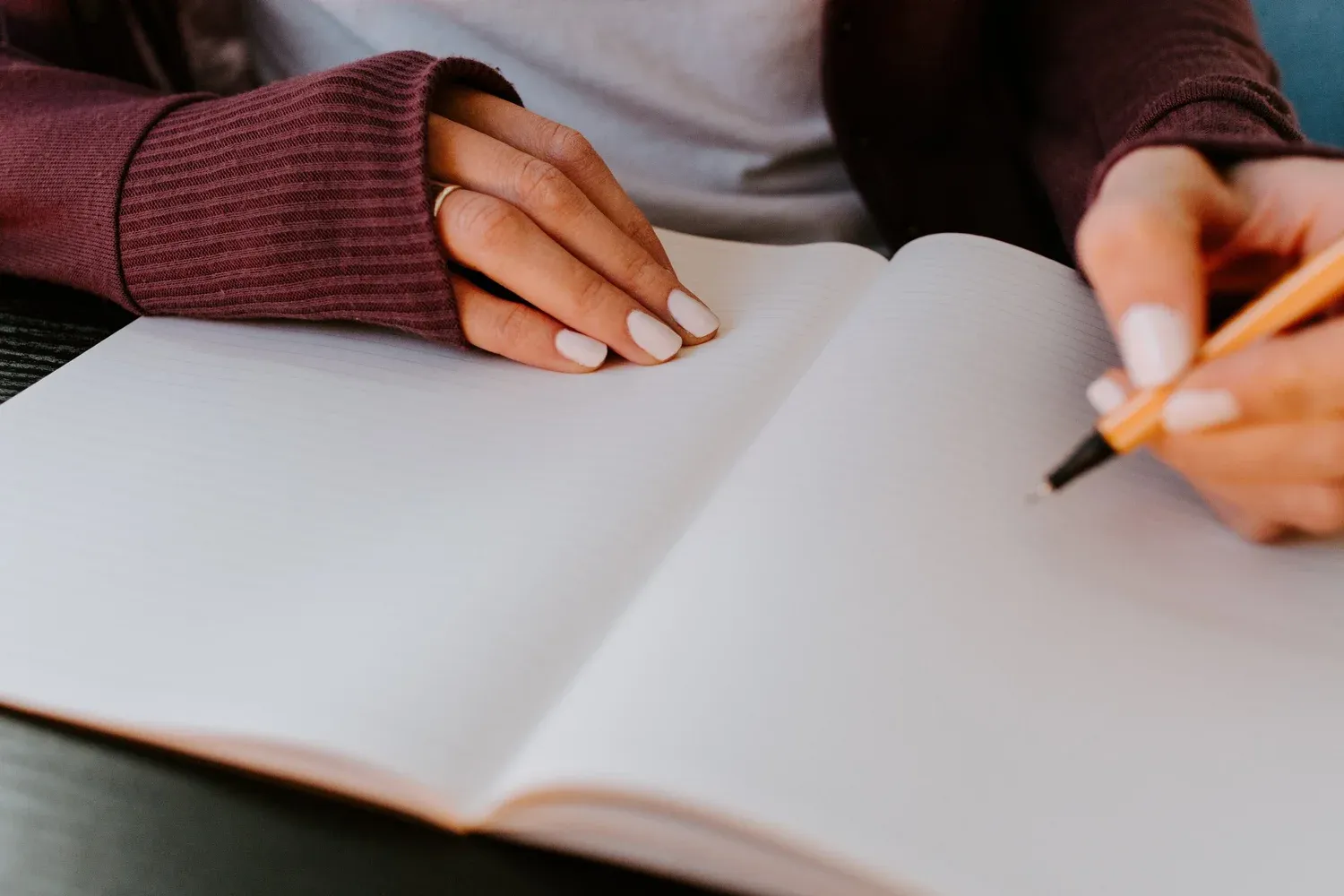 An open journal and pen on a desk, suggesting reflexive note-taking in qualitative research