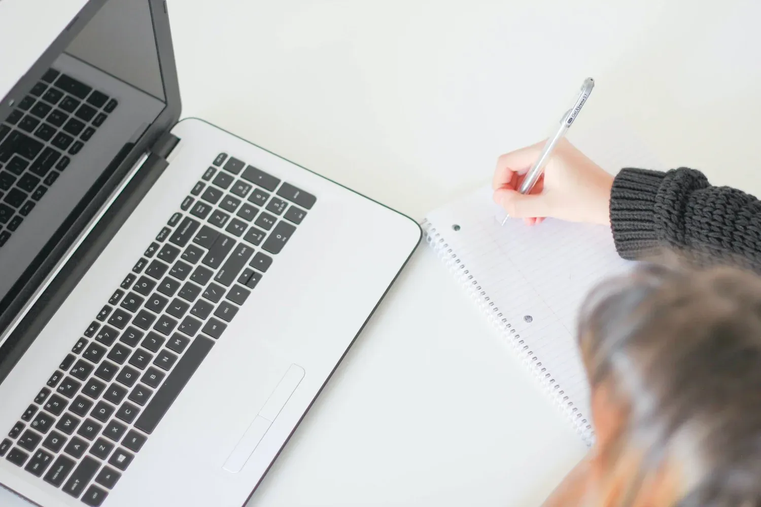 Person reading and analyzing documents at a desk